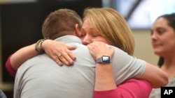 Plaintiffs Robbie Parker, left, and Nicole Hockley hug following the reading of the jury awards for damages in the Alex Jones defamation trial at Superior Court, Oct. 12, 2022, in Waterbury, Conn.