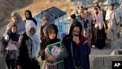 The family of a victim of a suicide bombing on a Hazara education center, goes to her grave for a mourning ceremony, in Kabul, Afghanistan, Oct. 2, 2022.