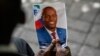 Seseorang memegang foto mendiang Presiden Haiti Jovenel Moise saat upacara peringatannya di National Pantheon Museum di Port-au-Prince, Haiti, 20 Juli 2021. (Foto: AP)