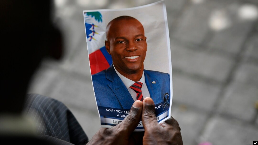Seseorang memegang foto mendiang Presiden Haiti Jovenel Moise saat upacara peringatannya di National Pantheon Museum di Port-au-Prince, Haiti, 20 Juli 2021. (Foto: AP)