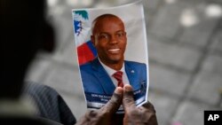 Seseorang memegang foto mendiang Presiden Haiti Jovenel Moise saat upacara peringatannya di National Pantheon Museum di Port-au-Prince, Haiti, 20 Juli 2021. (Foto: AP)