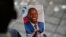 ARCHIVO - Una persona sostiene una fotografía del fallecido presidente haitiano Jovenel Moïse durante su ceremonia conmemorativa en el Museo Nacional del Panteón en Puerto Príncipe, Haití, el 20 de julio de 2021.