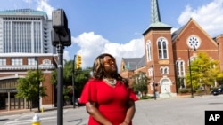 FILE - Khadidah Stone stands on the dividing line between her old Alabama congressional District 7, to her right with River City Church, and her new district, District 2, to her left, in downtown Montgomery, Alabama, Sept. 20, 2022. The line splits Montgomery between two congressional districts.