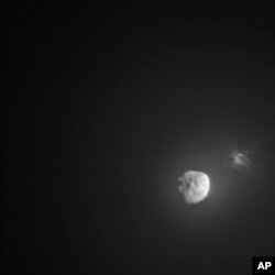 In this image made available by NASA, debris ejects from the asteroid Dimorphos, right, a few minutes after the intentional collision of NASA’s Double Asteroid Redirection Test (DART) mission on Sept. 26, 2022, captured by the nearby Italian Space Agency’