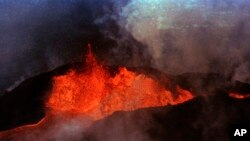 FILE - Molten rock flows from Mauna Loa on March 28, 1984, near Hilo, Hawaii.