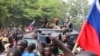 Burkina Faso's self-declared new leader Ibrahim Traore is welcomed by supporters holding Russian's flags as he arrives at the national television standing in an armoured vehicle in Ouagadougou, Oct. 2, 2022.