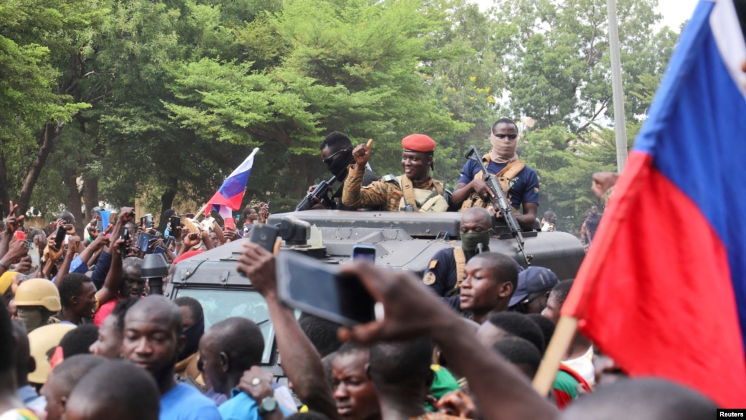Burkina Faso's self-declared new leader Ibrahim Traore is welcomed by supporters holding Russian's flags as he arrives at the national television standing in an armoured vehicle in Ouagadougou, Oct. 2, 2022.