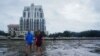 Sejumlah warga tampak berjalan di atas lumpur di area Tampa Bay, Florida, menjelang datangnya badai Ian ke wilayah tersebut pada 28 September 2022. (Foto: AFP/Bryan R. Smith)