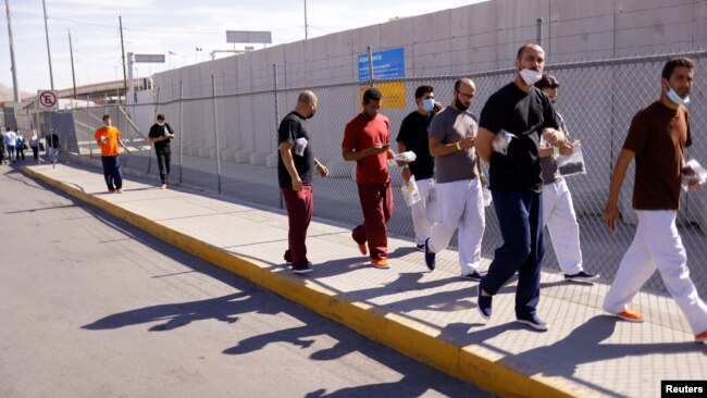 FILE - Cuban migrants who were expelled from the U.S. and sent back to Mexico under Title 42 walk near the at the Lerdo Stanton International border bridge, in Ciudad Juarez, Mexico, May 3, 2022.