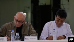 Antonio Garcia, of the Colombian guerrilla National Liberation Army (ELN), left, and Colombian government representative Ivan Danilo Rueda sign an agreement to resume peace talks, at the Casa Cultural Aquiles Nazoa in Caracas, Venezuela, Oct. 4, 2022.
