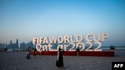 Visitantes toman fotos del anuncio del Mundial de Fútbol en Doha, Qatar, el 23 de octubre de 2022.