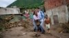 Une femme pleure en cherchant un membre de sa famille disparu dans une zone inondée à Las Tejerias, au Venezuela, dimanche 9 octobre 2022. 