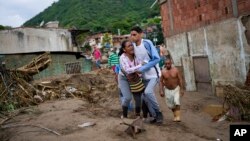 Une femme pleure en cherchant un membre de sa famille disparu dans une zone inondée à Las Tejerias, au Venezuela, dimanche 9 octobre 2022. 