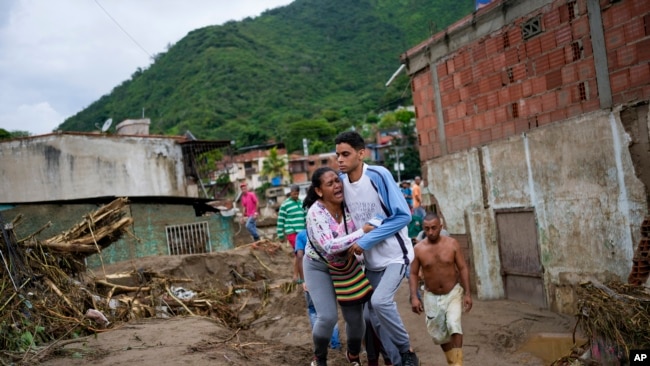 Una mujer llora mientras busca a un pariente desaparecido en un área inundada en Las Tejerias, Venezuela, el domingo 9 de octubre de 2022.(Foto AP/Matías Delacroix)