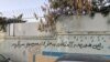 شعارنویسی روی دیوار یک مدرسه علی