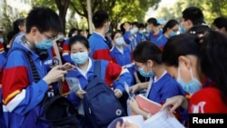 FILE - Students prepare to take part in the annual national college entrance exam outside a high school in Beijing, China July 7, 2020.