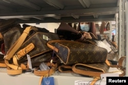 A customer looks at bags displayed at a store of second-hand luxury goods platform ZZER in Shanghai, China September 9, 2022. (REUTERS/Xihao Jiang)