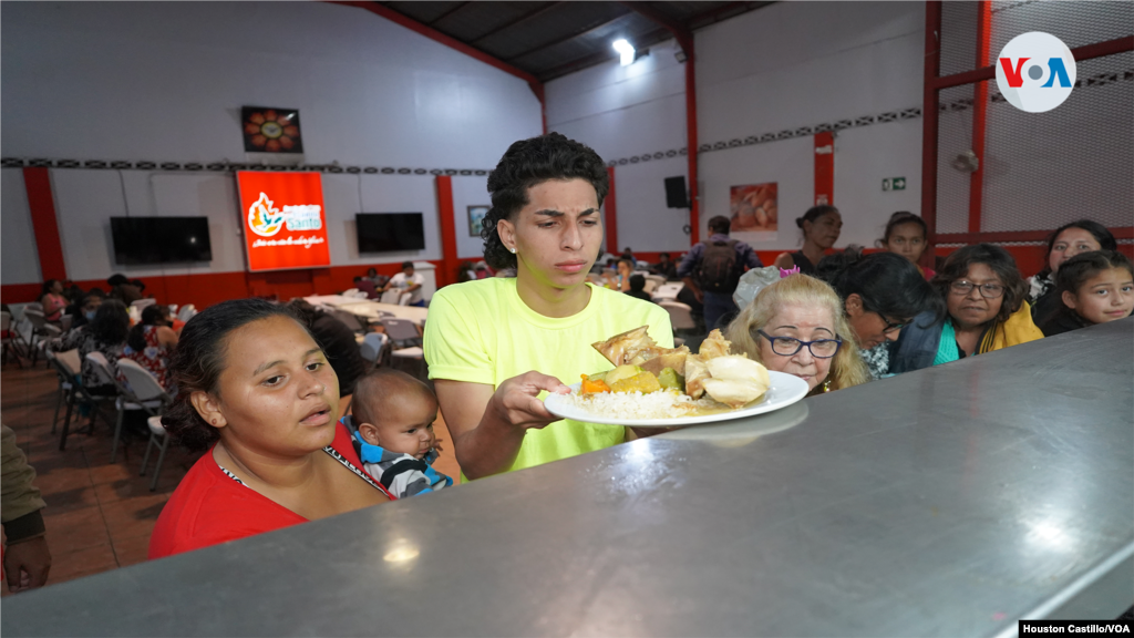 Venezolanos hacen fila paras recibir comida en la sede de la Asociación Obras del Espíritu Santo, en San José, Costa Rica.