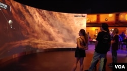 In the planets gallery, visitors take an immersive trip through the solar system to get a close-up look at the surface of planets and asteroids on a large scale. (Deborah Block/VOA)