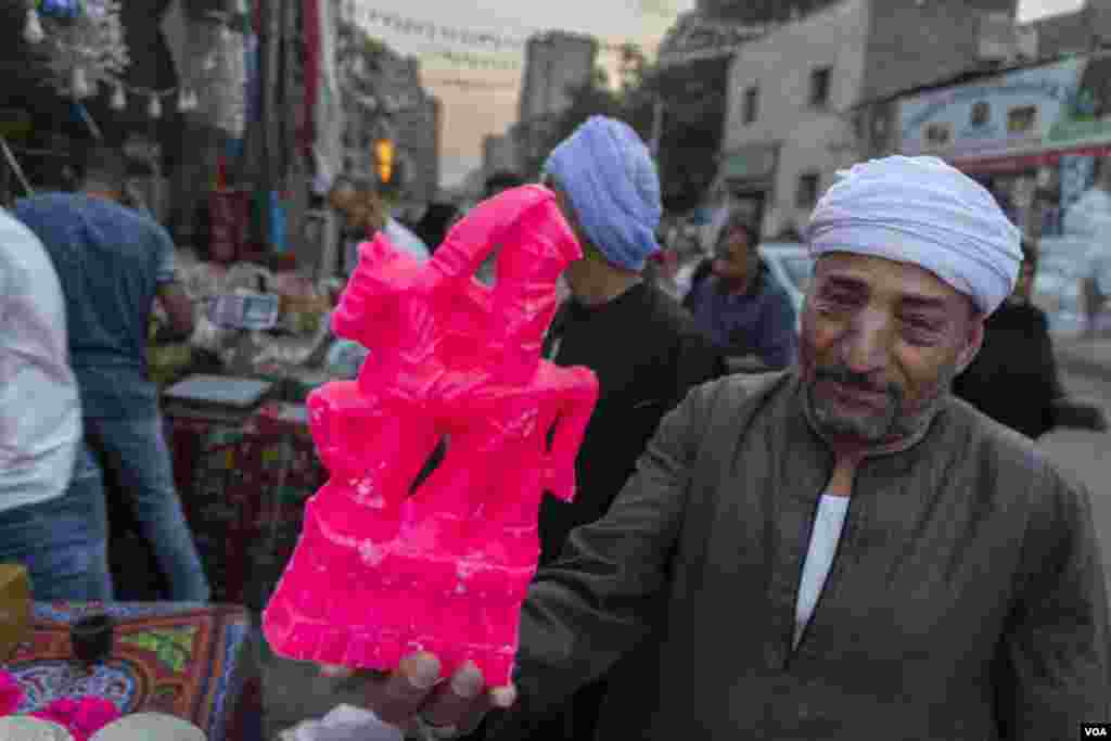 Ibrahim El-Khateb, a grocer who has sold Mawlid el-Nabi sweets for over three decades, says, “The sugar doll cost 10 Egyptian pounds (about $0.50) last year, but this year it’s for 50 ($2.50).” In Cairo, on Oct. 8, 2022. (Hamada Elrasam/VOA) 