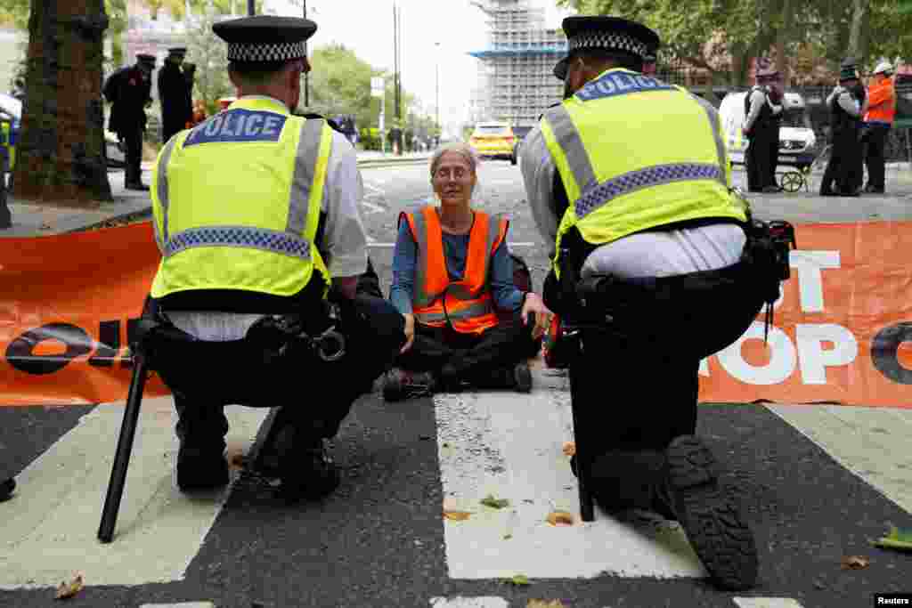 A "Just Stop Oil" protester blocks a road leading into Westminster, in London, Britain.