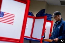 FILE - McArthur Myers fills out his ballot at an early voting location in Alexandria, Va., Sept. 26, 2022.