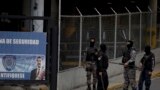 ARCHIVO - Un grupo de agentes de la policía política venezolana, SEBIN, con el rostro cubierto, hacen guardia en la puerta principal de la sede del SEBIN en Caracas, Venezuela, el miércoles 16 de mayo de 2018.