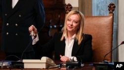 FILE - New Italian Premier Giorgia Meloni rings the cabinet minister bell during her first cabinet meeting at Chigi Palace Premier's office, in Rome, Oct. 23, 2022. 