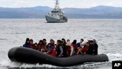 FILE: FILE - Migrants arrive with a dinghy accompanied by a Frontex vessel after crossing the Aegean sea. Taken Feb. 28, 2020