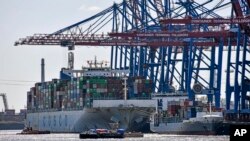 资料照：中国中远集团（Cosco）的集装箱船在德国汉堡港装卸货物。（2022年3月19日）
