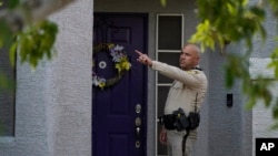 A police officer stands in front of the home of Robert Telles, suspected in the stabbing death of investigative reporter Jeff German, in Las Vegas, Nevada, Sept. 7, 2022. A judge is now reviewing whether police and prosecutors should gain access to German's electronic devices.