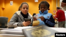 Inmigrantes sostienen su pasaporte en una oficina de inmigración en Granada, España, el 26 de enero de 2010.