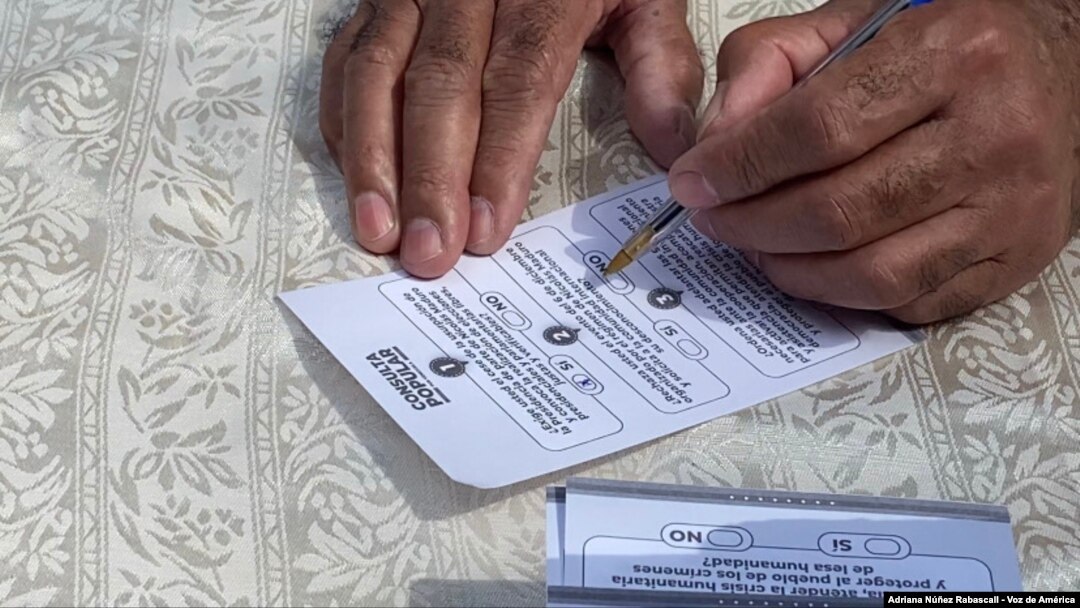 La foto muestra a un venezolano completando una boleta de la consulta popular organizada por la oposición el 12 de diciembre de 2020.