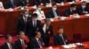 Former Chinese President Hu Jintao, front row second from right, talks to his predecessor as party leader Xi Jinping as he is assisted to leave the hall during the 20th National Congress of China's ruling Communist Party at the Great Hall of the People in Beijing, Oct. 22, 2022. 