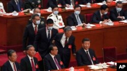 Former Chinese President Hu Jintao, front row second from right, talks to his predecessor as party leader Xi Jinping as he is assisted to leave the hall during the 20th National Congress of China's ruling Communist Party at the Great Hall of the People in Beijing, Oct. 22, 2022. 