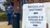 FILE - Signs showing the way for voters stand outside a Cobb County voting building during the first day of early voting, Oct. 17, 2022, in Marietta, Ga.