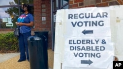 Carteles dirigidos a los votantes en un colegio electoral de Cobb County, en Marietta, Georgia, para una votación temprana, el 17 de octubre de 2022.