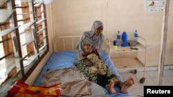 FILE - A Somali refugee holds a toddler at a hospital in the Dadaab refugee camp, Kenya, Dec. 19, 2017. Doctors Without Borders warned Oct. 27, 2022, of possible measles and cholera outbreaks in the camp as refugees arrive from Somalia, where the diseases are circulating.