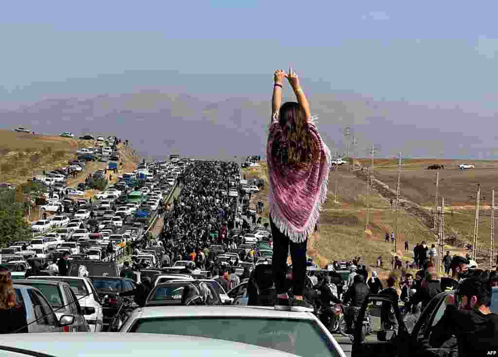 This UGC image posted on Twitter shows an unveiled woman standing on top of a vehicle as thousands make their way toward the Aichi Cemetery in Saqez, Mahsa Amini&#39;s home town in the western Iranian province of Kurdistan, to mark 40 days since her death,&nbsp;defying heightened security measures as part of a bloody crackdown on women-led protests.