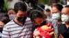 A family of a victim mourns as they bring a blanket and a baby bottle during a ceremony for those killed in the attack on the Young Children's Development Center in Uthai Sawan, Thailand, Oct. 7, 2022.