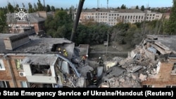 Los rescatistas trabajan en el sitio de un edificio residencial gravemente dañado durante un ataque militar ruso en Mykolaiv, Ucrania, el 13 de octubre de 2022.