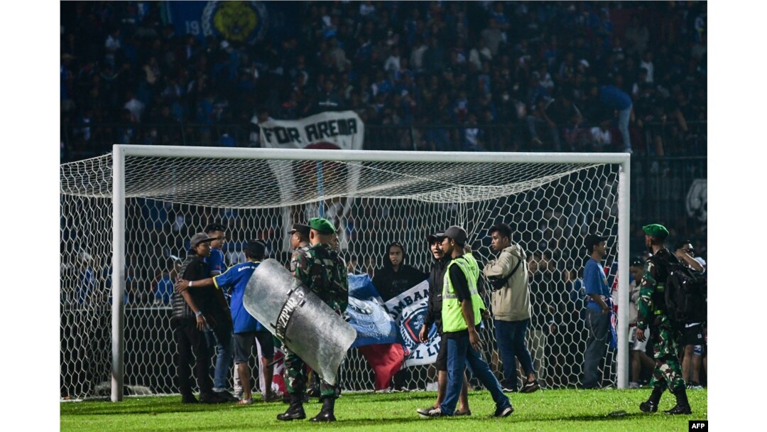 TNI dan Polri mengamankan lapangan usai pertandingan sepak bola Arema FC melawan Persebaya Surabaya di Stadion Kanjuruhan Malang, Jawa Timur (Foto: AFP)