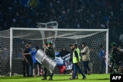 TNI dan Polri mengamankan lapangan usai pertandingan sepak bola Arema FC melawan Persebaya Surabaya di Stadion Kanjuruhan Malang, Jawa Timur (Foto: AFP)