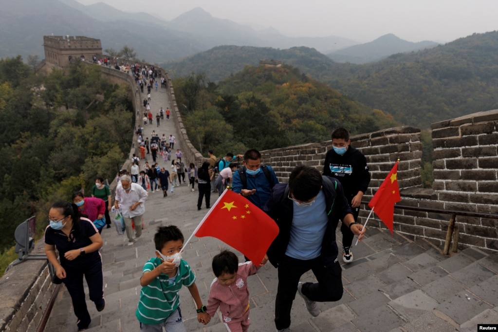 中国国旗日游客手拿国旗爬长城。（2022年10月1日）(photo:VOA)