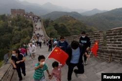 中国国旗日游客手拿国旗爬长城。（2022年10月1日）