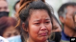 A relative mourns during a ceremony for those killed in the attack on the Young Children's Development Center in the rural town of Uthai Sawan, northeastern Thailand, Oct. 7, 2022.