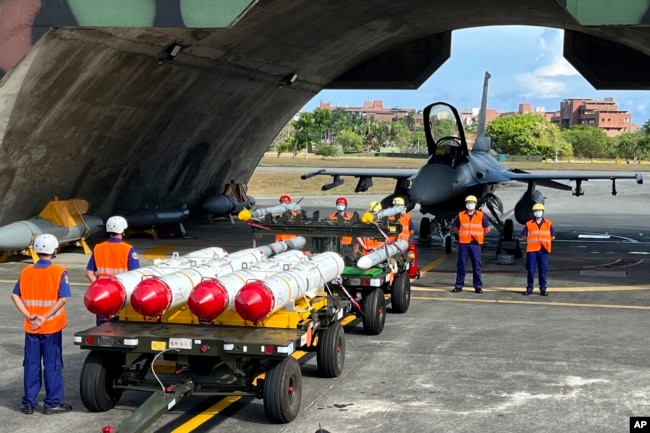 台灣軍隊士兵站在F16V戰機前，準備進行裝載美製AGM-84魚叉反艦導彈及AIM-120和AIM-9空空導彈的訓練。 （2022年9月16日）