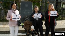 Родственницы защитников «Азовстали» держат в руках плакаты с надписью «Я жду», требуя освобождения из российского плена, Киев, 24 сентября 2022 года