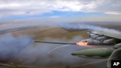 In this handout photo taken from video and released by Russian Defense Ministry Press Service, Oct. 16, 2022, an Su-25 ground attack jet of the Russian air force fires a rocket on a mission over Ukraine.