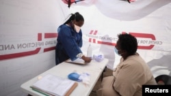 Gladys Rara undergoes screening before being tested for tuberculosis at a mobile clinic in Gugulethu township near Cape Town, South Africa, March 26, 2021. REUTERS/Mike Hutchings